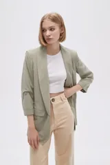 Blazer color verde oliva, de corte entallado y mangas 3/4 con botón.