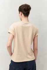 Remera blanca de manga corta con estampado floral en tonos dorados en el frente.