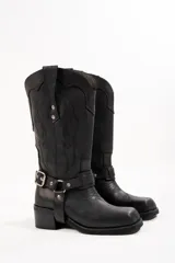 Bota de cuero color negro, estilo texana, con bordados en el lateral y correa con hebilla metálica alrededor del tobillo.