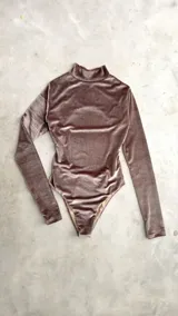 Body de terciopelo marrón con estampado de piel de serpiente, cuello alto, mangas largas con orificio para el pulgar y espalda descubierta.