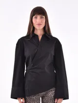 Camisa negra de manga larga con cuello clásico y cierre cruzado con botones.
