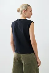 Musculosa negra con escote en V y bordado floral en el frente. Sin mangas y corte recto.