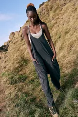 Mono largo negro con breteles finos, corte holgado, bolsillos laterales y entrepierna caída.