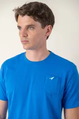 Remera azul con cuello redondo, manga corta, bolsillo en el pecho y logo bordado.