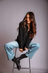 Buzo de punto color rosado, con cuello polo y cierre frontal parcial, de manga larga y diseño holgado.