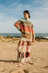 Sweater tejido a mano de lana merino, con cuello a la base y puños. Diseño a rayas horizontales en tonos celeste, marrón, naranja y amarillo.
