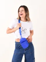 Riñonera azul con correa larga regulable, cierre superior y bolsillo frontal con cierre y diseño acolchado.