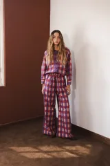 Pantalón palazzo con estampado de rayas verticales color borgoña y rosa, con motivos florales en las rayas borgoña. Tiene cintura elástica con cordón ajustable.