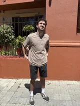 Remera negra con efecto gastado, corte amplio y estampado blanco en el pecho con motivos playeros.