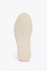 Zapatillas deportivas color beige, estilo soft, con cuerpo en combinación de materiales y cierre mediante cordones. Suela de 3 cm de altura.