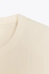Top color amarillo de punto liso con cuello redondo y manga corta.