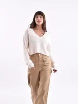 Sweater corto color beige con rayas horizontales negras, escote en V y mangas largas.