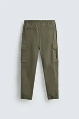 Pantalón cargo negro de corte slim fit, confeccionado en tejido de algodón con cintura elástica ajustable con cordón. Cuenta con bolsillos frontales, traseros y bolsillos tipo parche con solapa en los laterales.