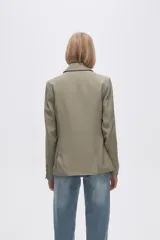 Blazer color crudo de rayon, entallado, con cuello solapa y cierre con un botón.