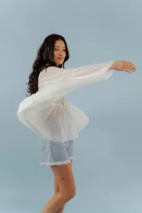 Camisa blanca de mangas largas con puntillas y cuello mao.