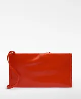 Bolso de mano rectangular color naranja brillante, con asa de mano y asa larga regulable extraíble. Tiene un compartimento con cierre magnético y logo grabado.