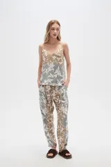 Musculosa de bretel fino con estampado floral en tonos beige, verde y blanco, corte al cuerpo y escote en V.