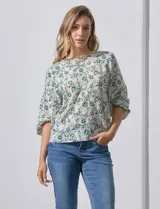 Blusa de gasa estampada con flores verdes sobre fondo blanco, de la marca Sioni. Tiene mangas cortas amplias con abertura y botón.
