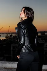 Chaqueta de cuero ovino color negro, con cierre frontal asimétrico y cuello con solapas.