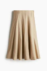 Pollera midi color beige con tiro alto, diseño circular y rayas cosidas. Presenta cierre oculto y corchete en un lateral. Sin forrar.