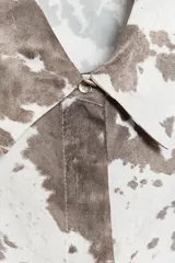 Camisa de manga larga con cuello solapa y estampado abstracto en tonos marrones y blancos. Cierre frontal con botones y bajo asimétrico.