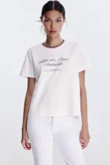 Camiseta blanca de algodón con cuello redondo y detalle de tricot a contraste en azul marino. Estampado frontal con texto "Estate sulla Costiera Amalfitana" en azul marino.