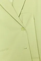 Blazer oversize color verde lima, con cuello solapa y mangas largas con hombreras. Tiene bolsillos delanteros y en el pecho, forro interior y cierre frontal multiposición.