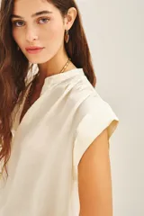 Camisa color crudo de corte amplio con mangas cortas y cuello mao, confeccionada en viscosa y modal.