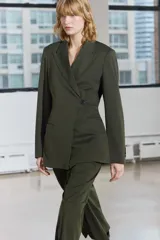 Blazer de Zara Woman Collection color verde musgo, de corte recto, con cuello solapa y manga larga. Tiene bolsillos de vivo en el delantero y cierre frontal cruzado con un botón.