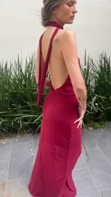 Vestido largo color borgoña, con escote drapeado y cuello halter. Tiene forro corto con transparencia.