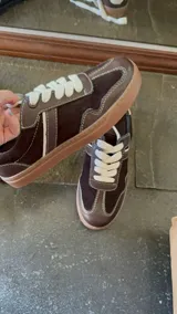 Championes de cuero color marrón oscuro con detalles en negro y blanco.
