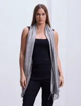 Pashmina gris con diseño a cuadros y flecos en los extremos.