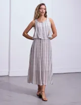 Vestido largo sin mangas, con estampado a rayas verticales en tonos beige, marrón y blanco. Tiene escote redondo y corte a la cintura con punto smock.