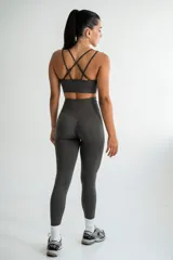 Conjunto deportivo negro, compuesto por un top con tiras cruzadas en la espalda y una calza de tiro alto con frunce en la parte trasera.