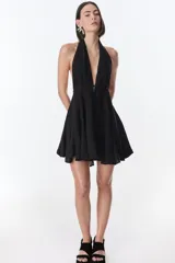 Vestido corto fucsia con escote halter y espalda descubierta.