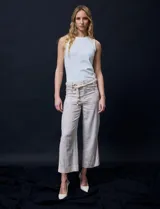 Pantalón capri de lino color beige con estampado floral, marca Zac & Rachel. Tiene pretina con pasadores, cierre y botón. Incluye cinturón de cordones con hebilla metálica. Presenta bolsillos delanteros con botones y bolsillos traseros.