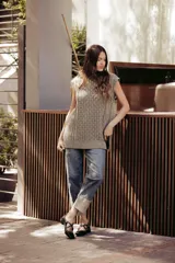 Chaleco de punto color crema con cuello alto y diseño de trenzas.