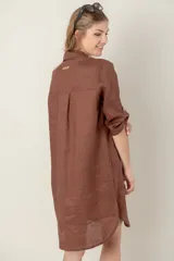 Vestido camisero negro de lino con botones, mangas 3/4 con trabilla y bolsillo de parche en el pecho con bordado de letras. Tiene aberturas laterales en el ruedo y costuras a contratono en color crudo.