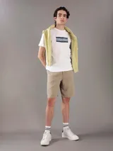 Remera blanca de algodón con cuello redondo y manga corta. Presenta un estampado rectangular con rayas horizontales en tonos de gris y azul, y el logo de Calvin Klein en el centro.