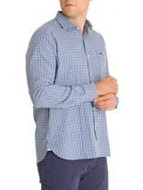 Camisa de manga larga con cuello italiano y bolsillo en el pecho con logo bordado. Diseño a cuadros en tonos azul, blanco y negro.