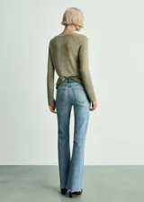 Pantalón de jean celeste de corte acampanado, tiro medio y bajo deshilachado.