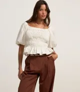 Pantalón pantalona de sastrería color marrón, con pliegues delanteros, cintura con trabillas y corte amplio.