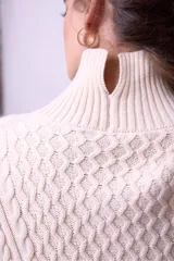 Sweater de punto color borgoña con cuello alto y diseño trenzado.