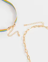 Set de dos chokers: uno con cadena dorada y dijes de letras, y otro con cinta de arcoíris.