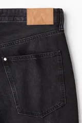 Bermuda de denim negro, corte relaxed, con cinco bolsillos y largo hasta la rodilla.