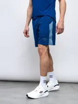Short deportivo azul con paneles laterales en celeste y logo Umbro estampado en la pierna izquierda.