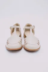 Sandalias bajas negras de cuero con pulsera al tobillo y talón cubierto. Presentan aberturas circulares en la capellada y taco de madera.