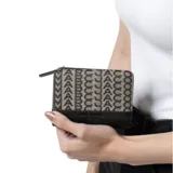 Billetera mini compacta Marc Jacobs, confeccionada en tejido con monograma beige y negro, con ribetes de cuero negro. Tiene cierre con botón a presión, seis ranuras para tarjetas, compartimento para billetes, cuatro bolsillos y monedero exterior con doble refuerzo.