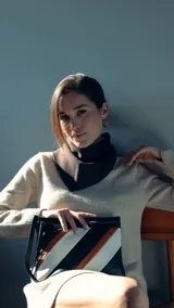 Sobre de mano de símil cuero con diseño de franjas diagonales en negro, blanco y marrón. Cuenta con cierre metálico frontal, bolsillo interior con cierre y otro abierto con división. Incluye correa desmontable para usar como bandolera.