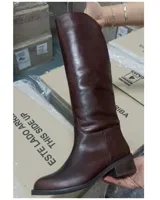 Bota de caña alta color marrón de cuero vacuno, con taco bajo y punta redondeada.